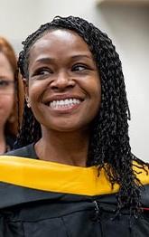 A graduating student smiles about connecting with fellow alumni
